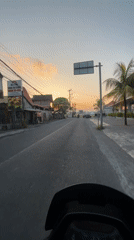 White smoke blankets a North Kuta street at golden hour
