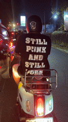 Punk-shirted rider spotted on white scooter in Mengwi