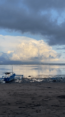Dramatic clouds gather over traditional boats at Denpasar beach