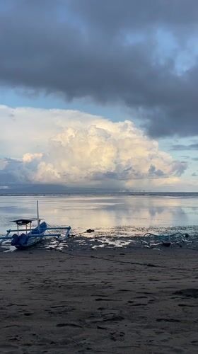 Dramatic clouds gather over traditional boats at Denpasar beach