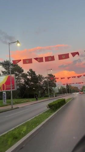 Red flags with golden emblems displayed on Podgorica street