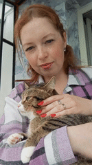 Woman holds tabby cat in Yurgamysh, Russia