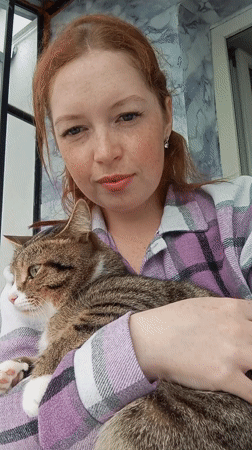 Woman holds tabby cat in Yurgamysh, Russia