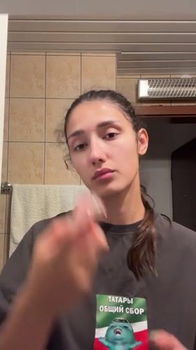 Woman performs evening skincare routine in Montenegro bathroom