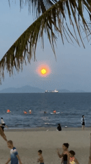 Orange moon rises over ocean at Đà Nẵng beach