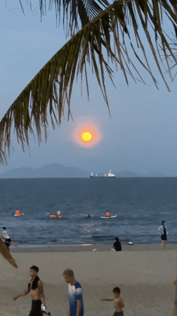 Orange moon rises over ocean at Đà Nẵng beach