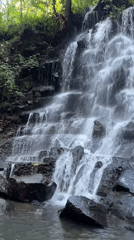 Multi-tiered waterfall documented flowing over rocks in Gianyar, Indonesia