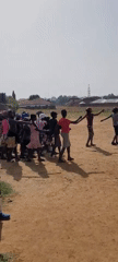 Children practice marching band on dirt field in Nigeria