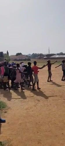 Children practice marching band on dirt field in Nigeria