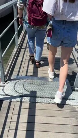 The video shows a group of people boarding a white motor yacht named "Marco Polo." The yacht is docked at a wooden pier. People are walking along the pier, and some are boarding the boat. A family with a stroller is already on board. The sky is blue, and the sun is shining.