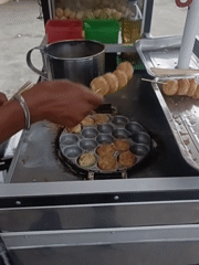 Skewered street snacks cooking at a cart in Keude Lueng Putu