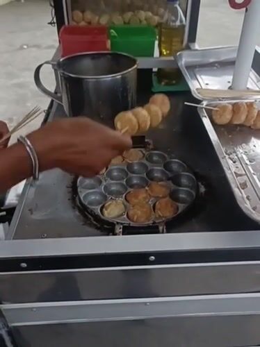 Skewered street snacks cooking at a cart in Keude Lueng Putu