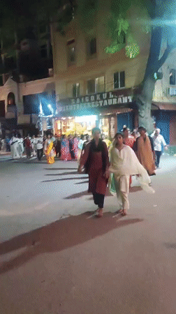 Crowd walks Puttaparthi streets in traditional Indian dress