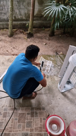 Man performs morning household maintenance in Baan Mae Nam