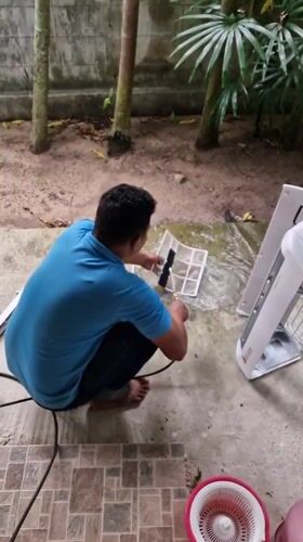 Man performs morning household maintenance in Baan Mae Nam