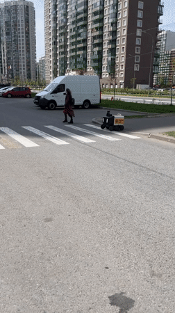 Pedestrian, delivery robot share crosswalk in Murino, Russia