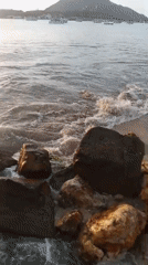 Sunset over Juan Griego's waterfront, boats and breakwater in view