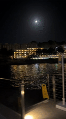 Full moon night at a waterfront resort pool