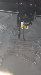Laser engraver cuts lobster design into metal in Luxembourg workshop