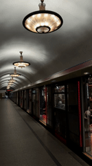 Moscow subway train stops at ornately lit platform