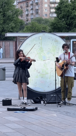 Moscow street musicians perform while zoo visitors feed animals