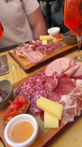 Two diners enjoy charcuterie boards outdoors in Corsico