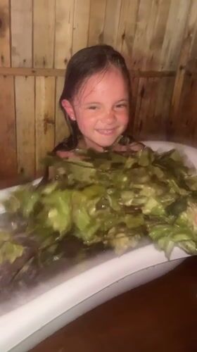 Bathing with green leaves in a rustic wooden room