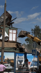 Excavator demolishes green wooden house in Hrodna, Belarus