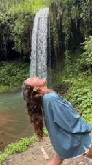 Tourists Document Waterfall Visit in Indonesian Jungle Setting