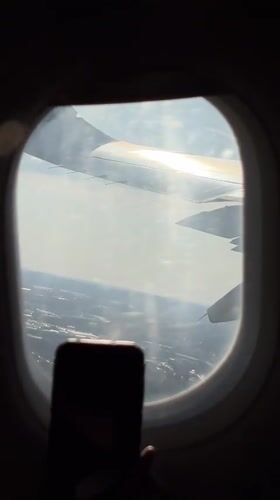 Aircraft wing filmed from passenger window over Orlando