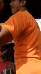 Man dances in gazebo while woman watches phone, Venezuela