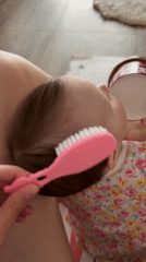 Parent brushes baby's hair during morning routine in Russia