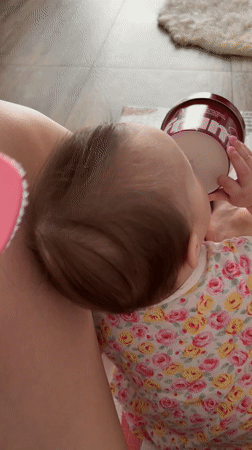 Parent brushes baby's hair during morning routine in Russia