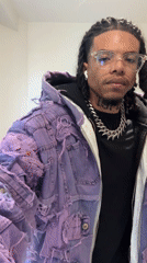 Man in purple jacket makes gestures in Massy bathroom