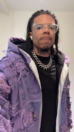 Man in purple jacket makes gestures in Massy bathroom