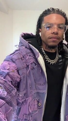 Man in purple jacket makes gestures in Massy bathroom