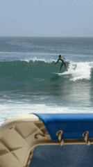 Surfer rides waves off Dakar coast during cloudy afternoon
