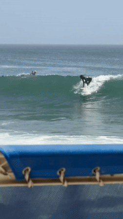 Surfer rides waves off Dakar coast during cloudy afternoon