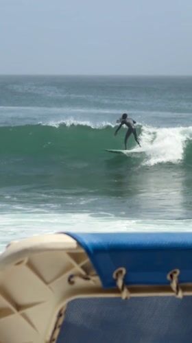 Surfer rides waves off Dakar coast during cloudy afternoon