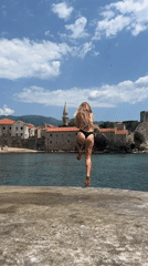 Woman enjoys seaside morning in Budva, flute spotted nearby