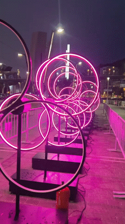 Neon ring installations and river boats light up Bilbao at night