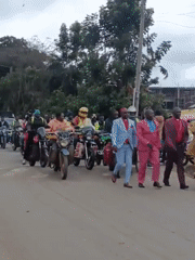 Suited men lead procession through busy Maua ward street
