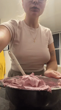Woman prepares pink frosting in Tel Aviv kitchen