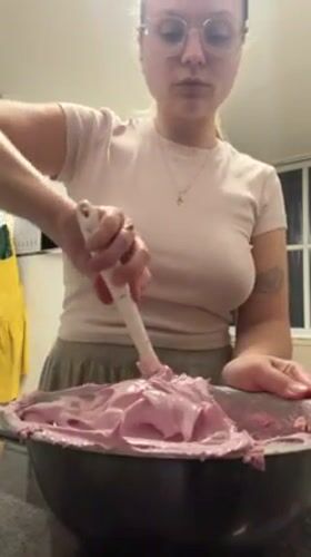 Woman prepares pink frosting in Tel Aviv kitchen