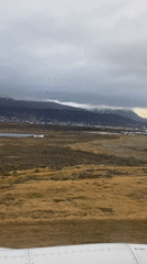 Aerial view captures Argentine mountains, grassland from airplane window