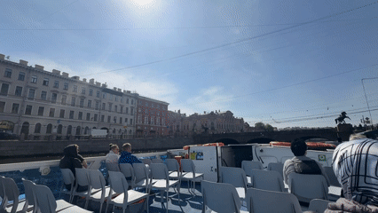 Tourist boat cruises Saint Petersburg canal past historic landmarks