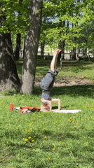 Woman does headstand yoga in Saint Petersburg park
