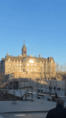 Couple stands at Montreal crosswalk near historic ornate building