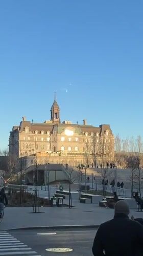 Couple stands at Montreal crosswalk near historic ornate building