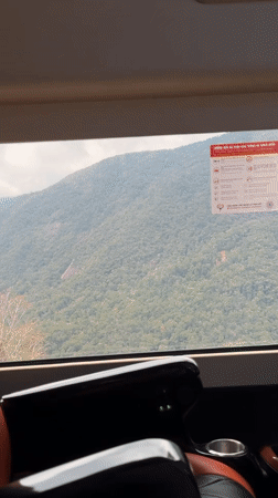 Passenger observes forested mountains from moving vehicle in Vietnam